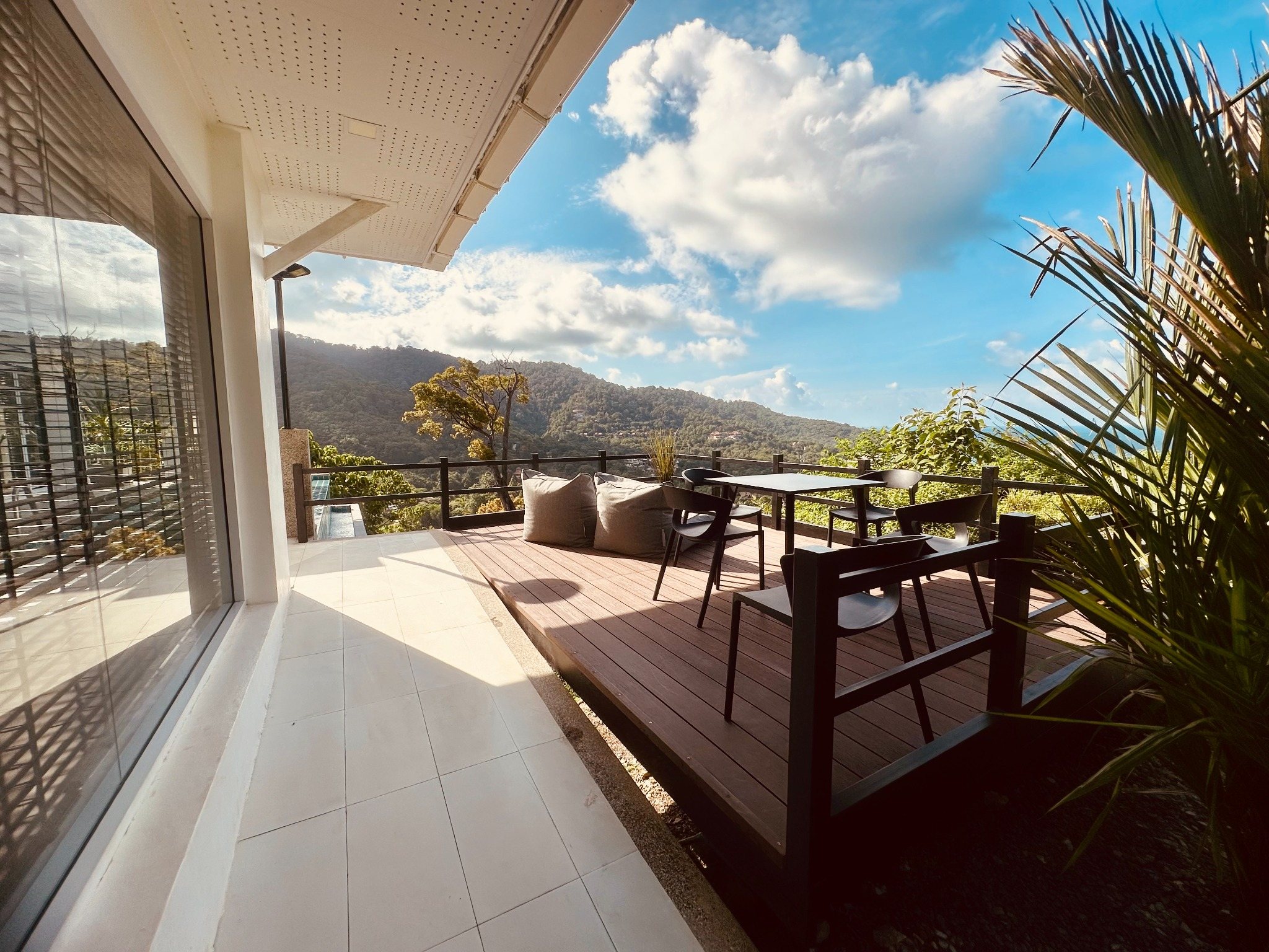 Outdoor dining terrace with sea and hillside views